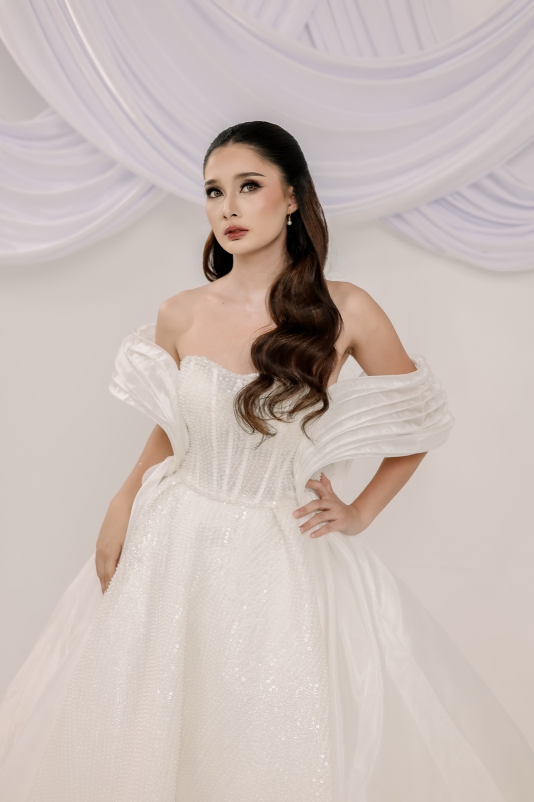 Riasan glam dengan rambut bergelombang panjang